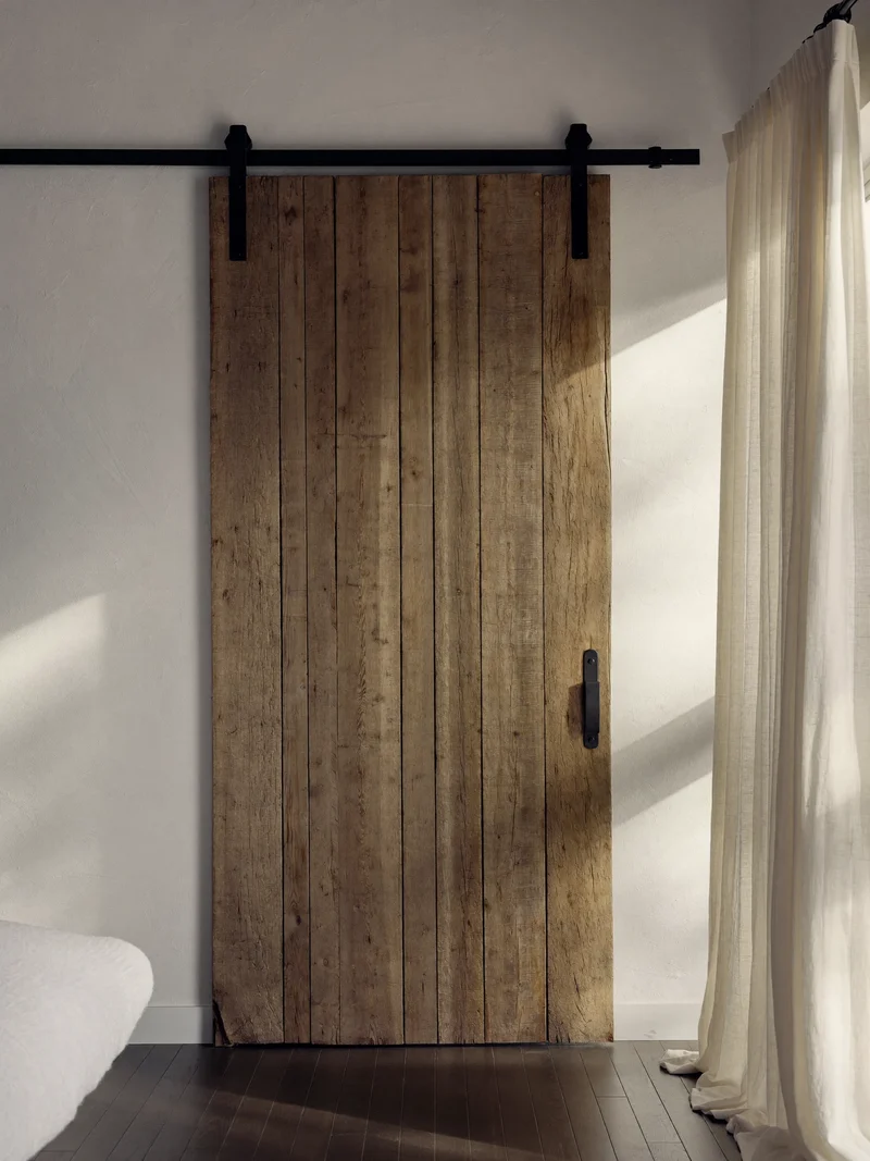Porta scorrevole rustica in assi di legno su binario nero